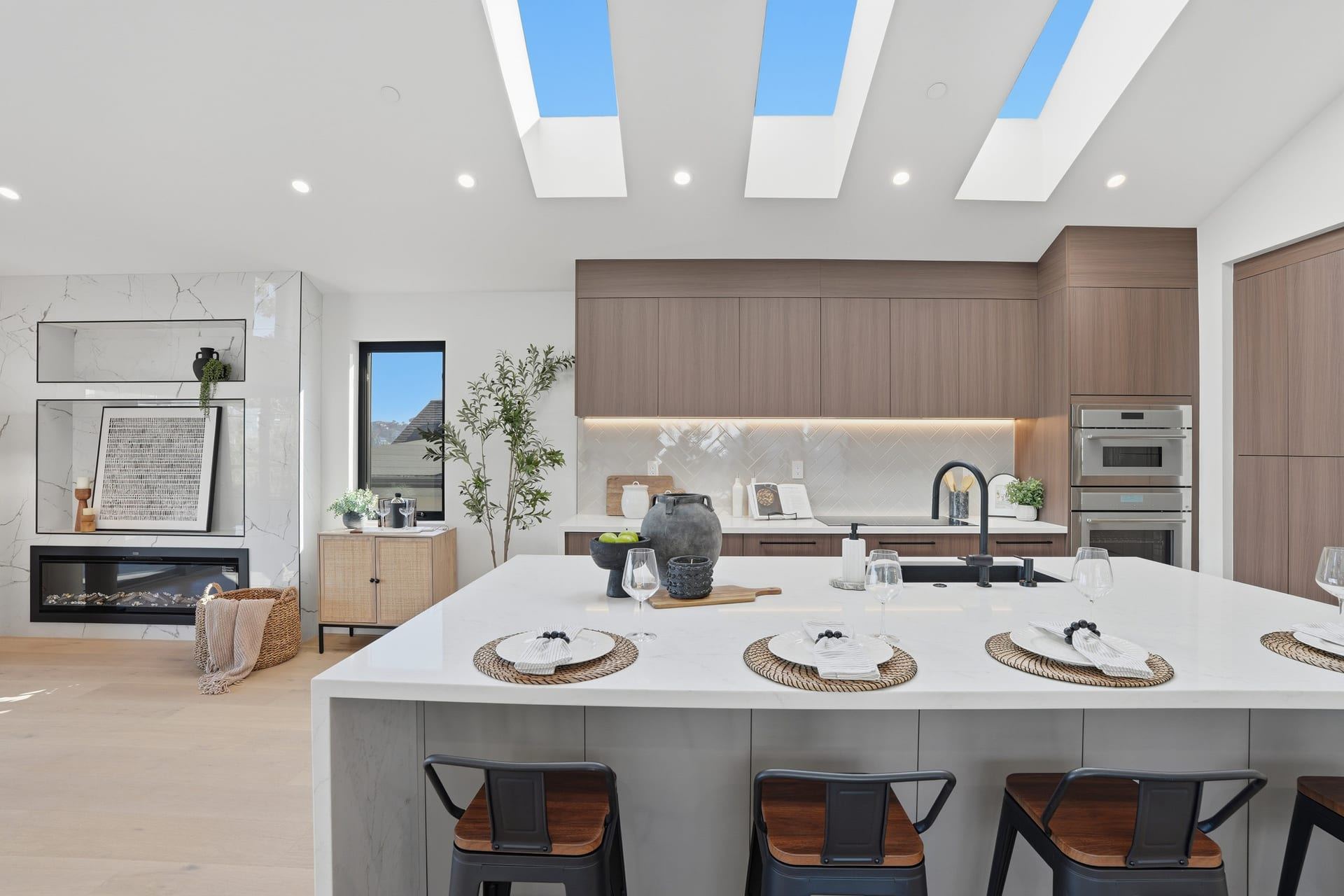 Modern wood kitchen with waterfall island and triple skylights
